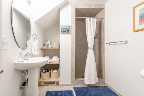 a white bathroom with a sink and a shower at The Perch at Eagle Harbor in Bainbridge Island
