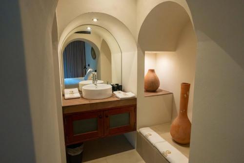 łazienka z umywalką i lustrem w obiekcie Cuatro Lunas Hotel Boutique w mieście Palenque