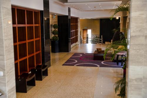 a hallway of a hotel with a lobby with plants at Hotel Continental Luanda in Luanda