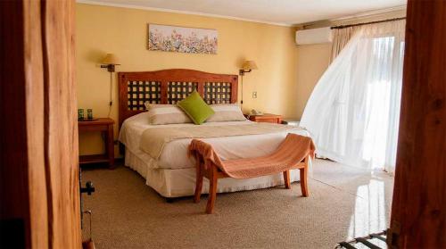 a bedroom with a large bed and a window at Casa Bosque Lodge in San José de Maipo