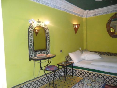 a bedroom with a bed and a mirror on the wall at Dar Ayour appartements in Essaouira