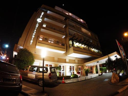 a building with cars parked in front of it at night at Hotel Continental Luanda in Luanda