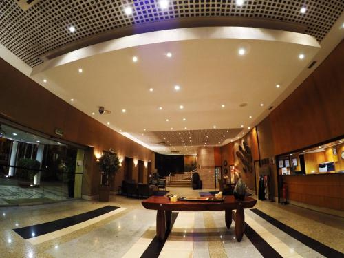 a lobby with a table in the middle of a building at Hotel Continental Luanda in Luanda