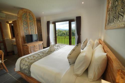 a bedroom with a large bed with a window at The Alugara Suite & Spa in Tegalalang