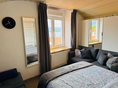 a bedroom with a bed and a couch and a clock at VRBNIK OLD CITY LOFT in Vrbnik