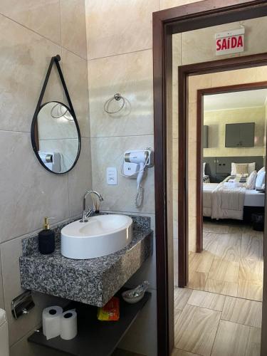 a bathroom with a sink and a mirror at Pousada Pé da Serra - Rio do Rastro in Lauro Müller