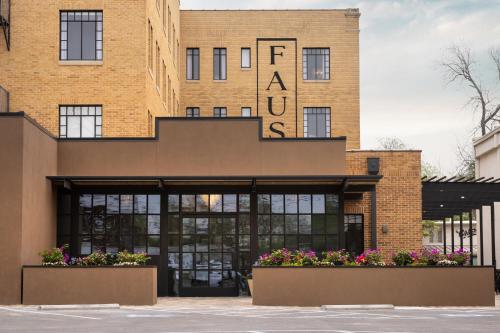 a brick building with flowers in front of it at The Faust Hotel in New Braunfels