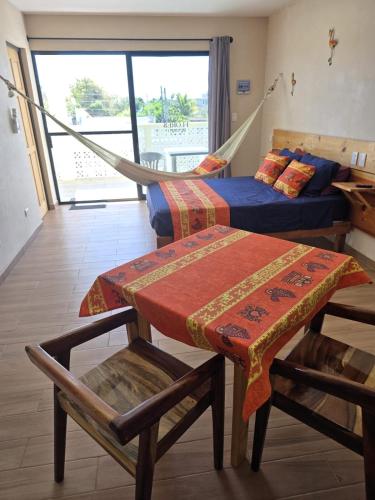 a room with two beds and a hammock in it at Casa Flores de Mayo in Chicxulub