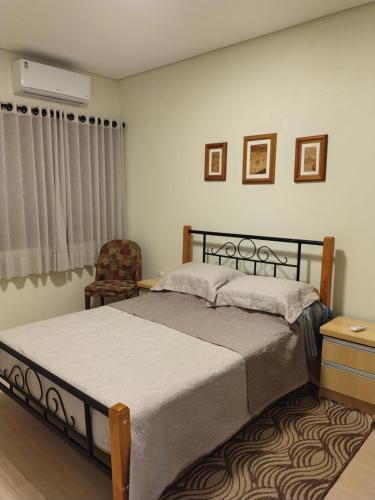 a bedroom with a bed and a chair at Pousada Relicário in Nova Petrópolis
