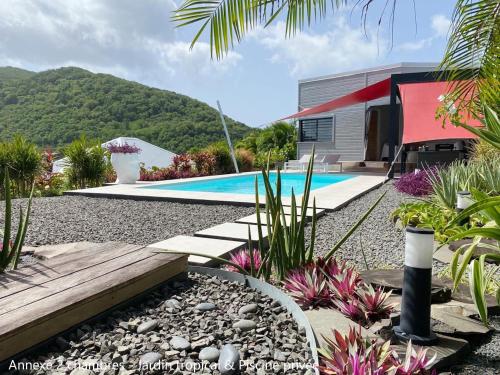 a backyard with a swimming pool and a house at Villa Coco Cannelle in Deshaies