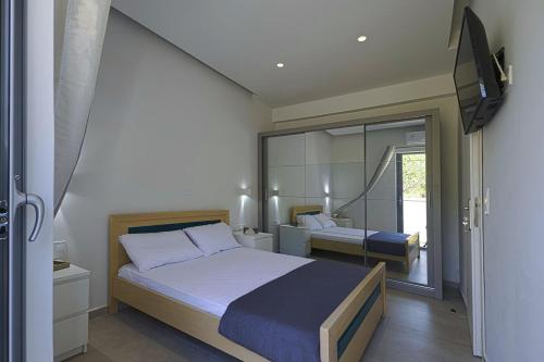 a bedroom with a bed and a mirror at Lontos Luxury Seaside House in Flampouria