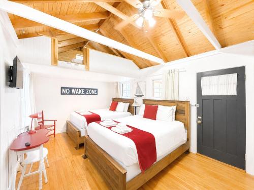 a bedroom with two beds and a black door at Cottage 8-9 - Stand Alone 2 Bedroom 2 Bath Private Courtyard Pet Friendly with Fee in Wolfeboro