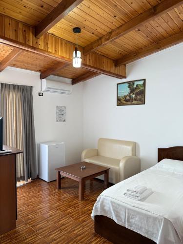 a bedroom with a bed and a couch and a table at Kompleksi Jakaj in Velipojë