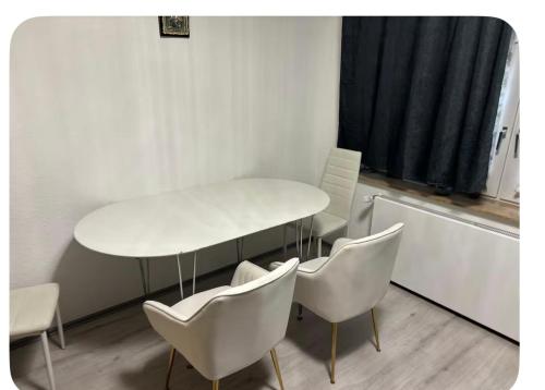 a white table and chairs in a room at Mitte Drin! Nahe Düsseldorf in Hilden