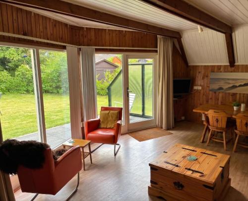 a living room with sliding glass doors and a table at Utpuster in Lauwersoog