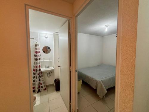 a small bedroom with a bed and a sink at Casa Real Santa Fe Cuernavaca in Atlacholoaya
