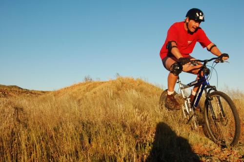 a man riding a bike down a grassy hill at The Vale Karoo Farm in Nelspoort
