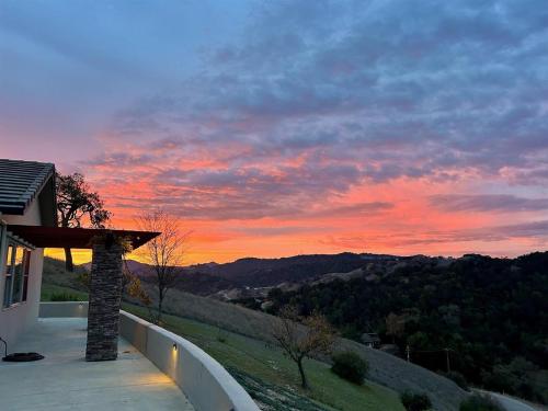 a sunset from the balcony of a house with a view at Hilltop Vistas Pool, Wine & Family Fun in Atascadero