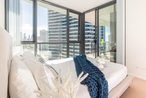 a white couch in a room with a large window at Modern Broadbeach 2BR Apartment - Pet Friendly in Gold Coast