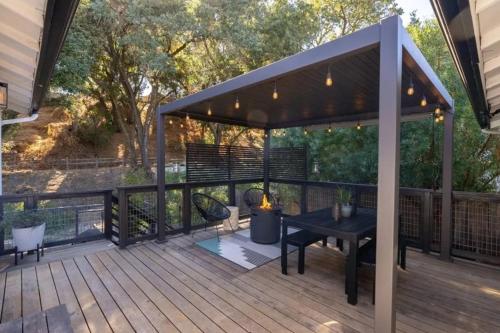 a pergola on a deck with a table and chairs at Templeton Creekside Cottage Walk to Downtown in Templeton