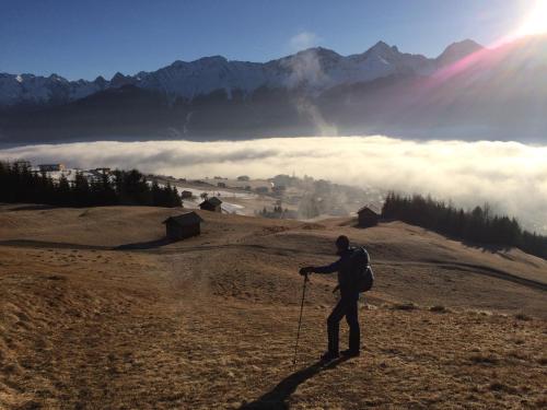 a man standing on top of a mountain looking at the clouds at Appart Gfall in Ried im Oberinntal