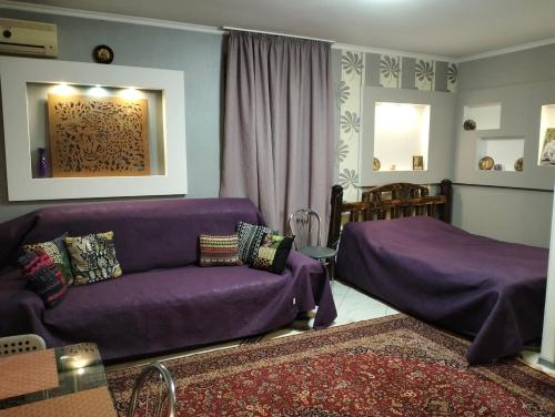 a living room with a purple couch and a bed at Apartment on 8 Marta in Mykolaiv