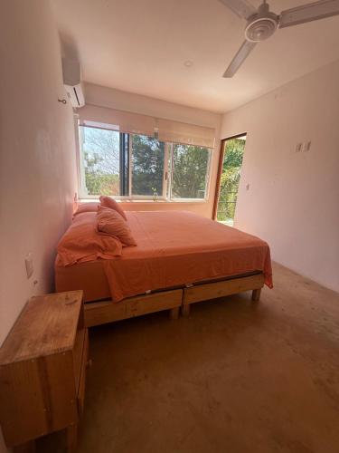 a bedroom with a bed in a room with windows at Pool, Space, Style, Modern House for 8 in Brisas de Zicatela