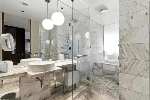 a bathroom with two sinks and a shower and a tub at Palms Place Hotel Mountain View with Open Balcony in Las Vegas