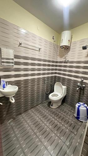 a bathroom with a toilet and a sink at Femina Residency in Kumbakonam