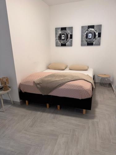 a bedroom with a bed and two pictures on the wall at Smile home, Zaanse schans and Amsterdam Appartements in Wormerveer