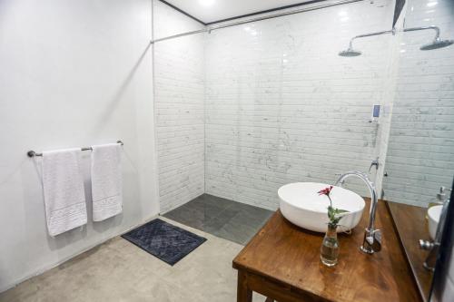 a white bathroom with a sink and a shower at Bobocha Tangkoko Nature Resort in Bitung
