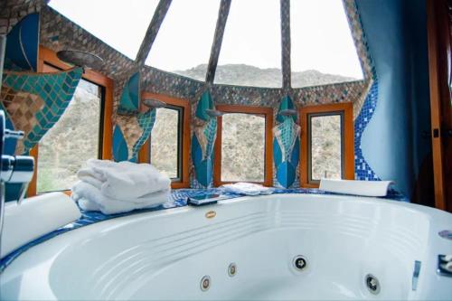 a white tub in a bathroom with windows at Casa Bosque Lodge in San José de Maipo