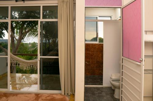 a bathroom with a toilet and a large window at Montero Residences in Brisas de Zicatela