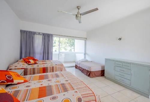 a bedroom with two beds and a window at Quinta las flores de Elizondo in Xochitepec