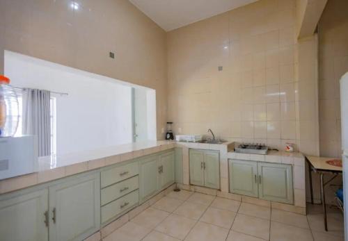 a large kitchen with white cabinets and a window at Quinta las flores de Elizondo in Xochitepec