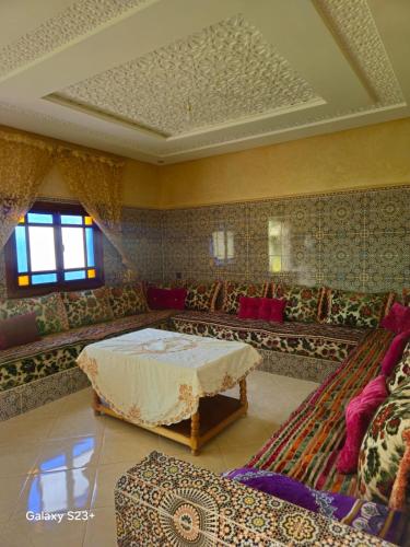 a living room with a bed and a couch at Villa du bonheur Chambres d'hote in Ouled el guerne