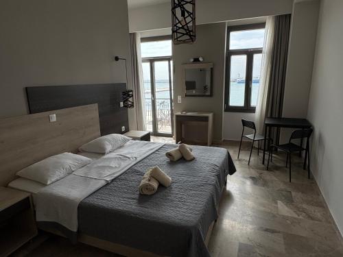 a bedroom with a bed with two towels on it at The Stonehouse at the Harbor in Pythagoreio