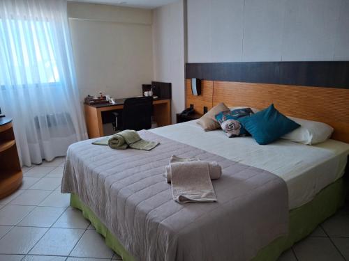 a hotel room with two beds with towels on them at Um lar aconchegante na rota do sol in Natal