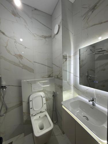 a bathroom with a toilet and a sink and a mirror at Alfas Beach Apartments in Shëngjin