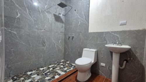 a bathroom with a toilet and a sink at Estadía Climatizada en Escuintla in Escuintla