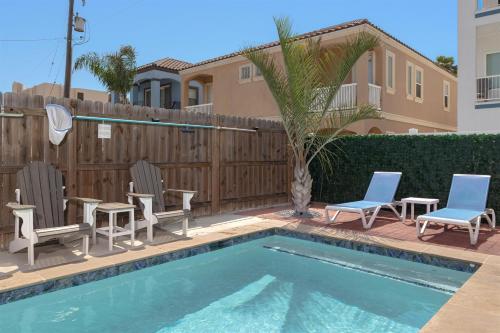 a backyard with a pool and chairs and a fence at House of Neptune Steps from the sea and private pool in South Padre Island