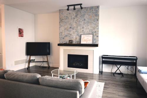 a living room with a couch and a fireplace at Modern 3 bedroom duplex home in Langley in Langley