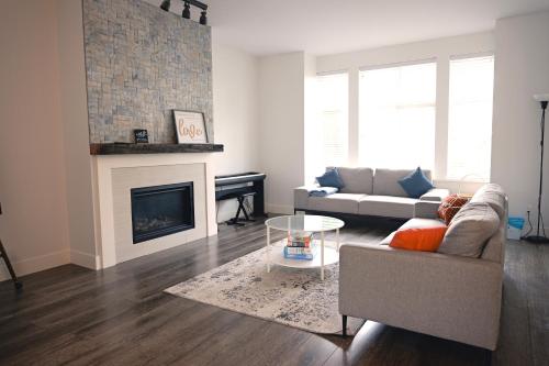 a living room with a couch and a fireplace at Modern 3 bedroom duplex home in Langley in Langley