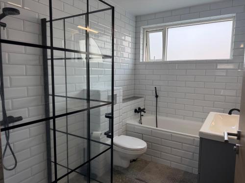 a white bathroom with a toilet and a sink at Hugleikshus in Hvolsvöllur