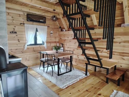 a dining room with a table and stairs in a log cabin at Durmitor sky in Žabljak