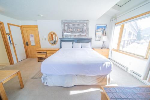 a bedroom with a large white bed and a window at Lenawee 1728 by SummitCove Lodging in Colorado in Keystone