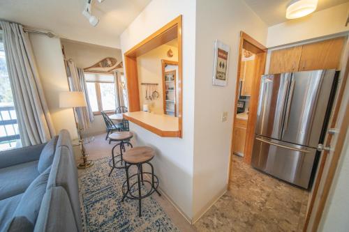 a living room with a couch and a kitchen with a refrigerator at Lenawee 1728 by SummitCove Lodging in Colorado in Keystone