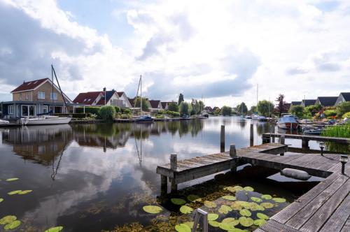 a view of a river with a dock and houses at Villa Water en Meer in Terherne