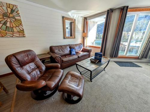 a living room with leather furniture and a table at Lakeside 1485 by SummitCove Lodging in Colorado in Keystone