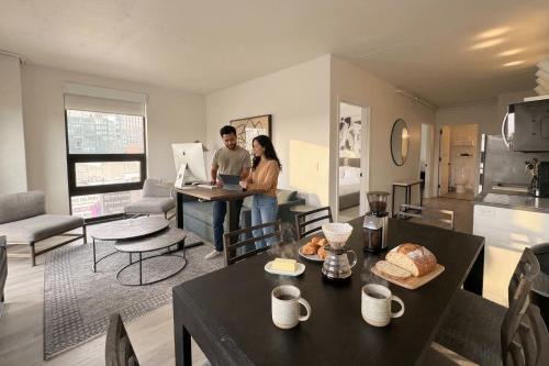 a man and a woman standing in a living room at Court Square Hotel Long Island City New York , Belvilla District 6 Formerly Sonder in Long Island City